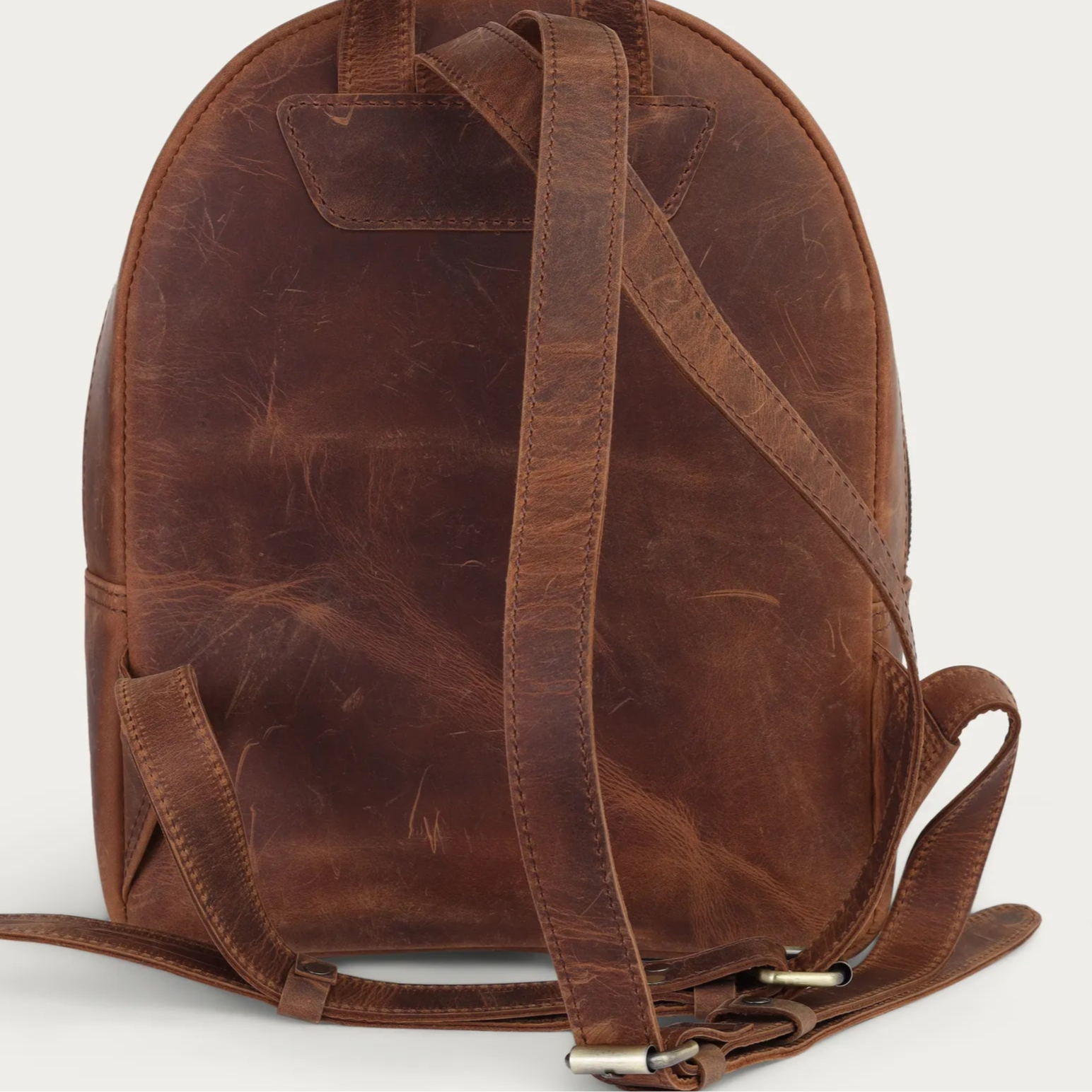 Brown leather backpack on a light gray background