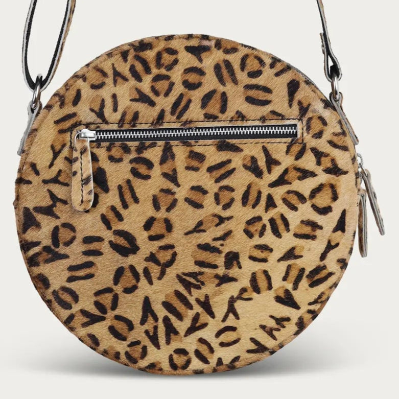 Round crossbody bag with leopard print pattern on a grey background