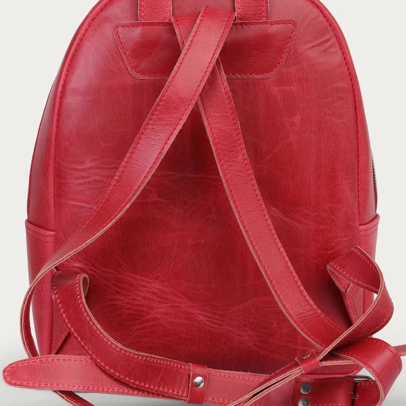 Red leather backpack on a light gray background