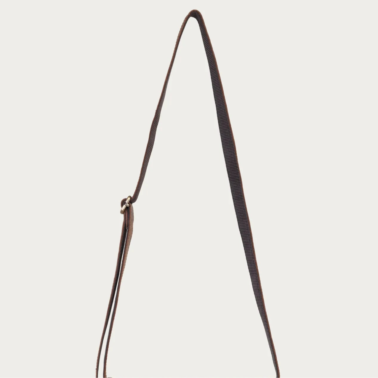 Brown leather satchel bag on a light gray background
