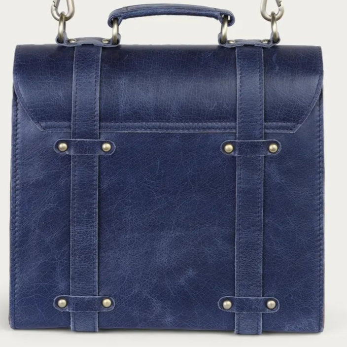 Blue leather bag with a strap on a light gray background