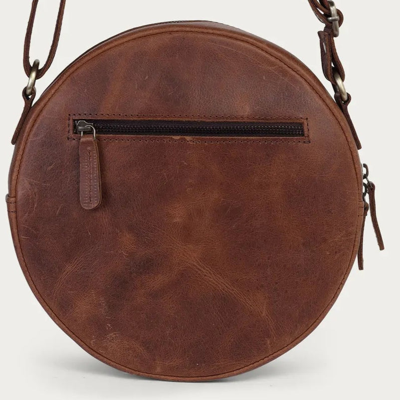 distress Brown leather round bag with a strap on a light gray background