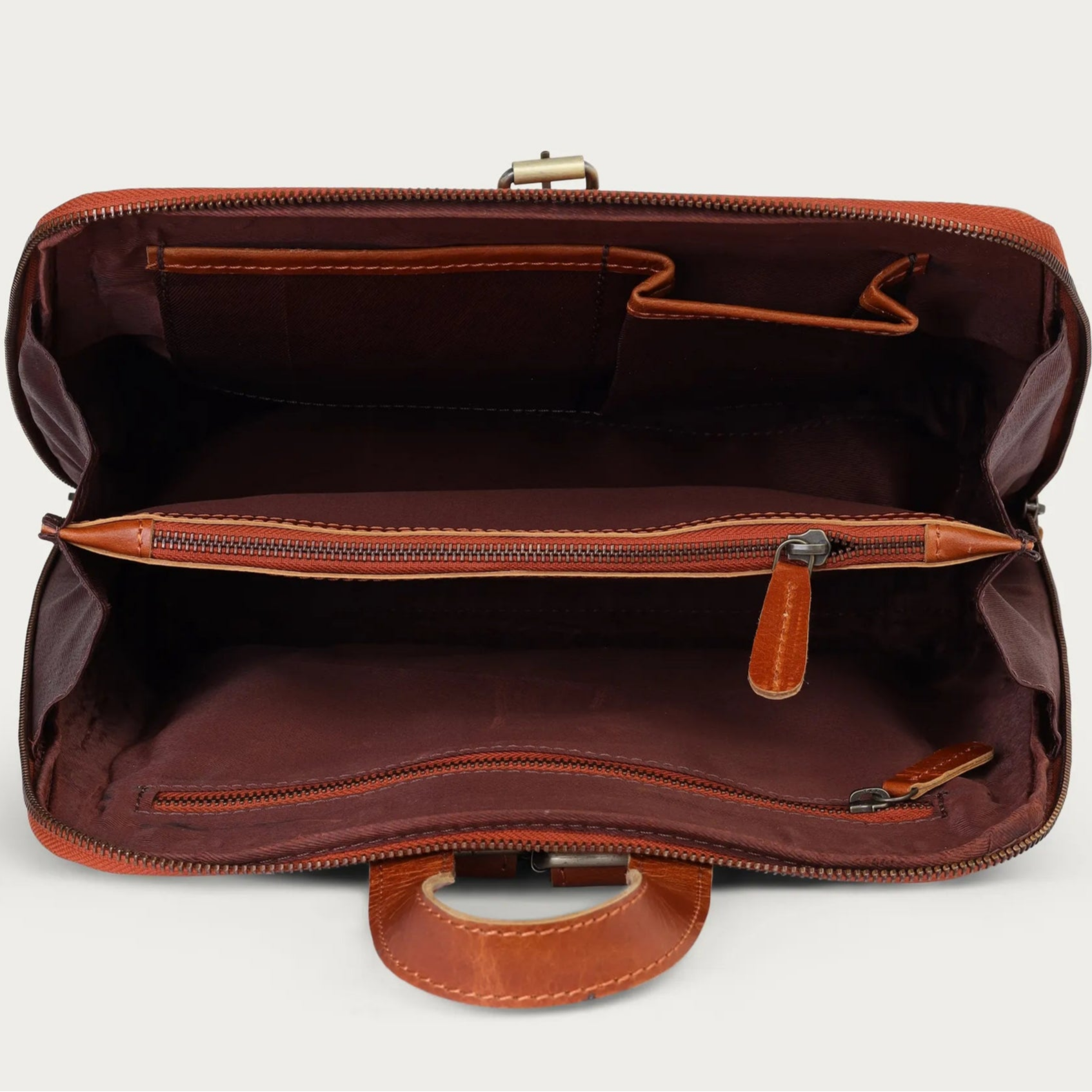 Brown leather bag with open interior on a light gray background