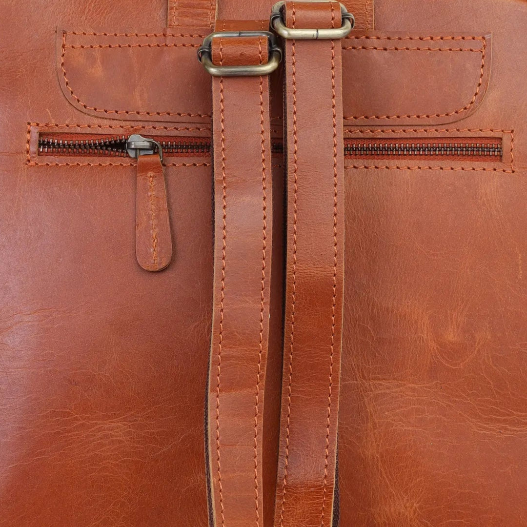 Tan leather backpack on a light gray background