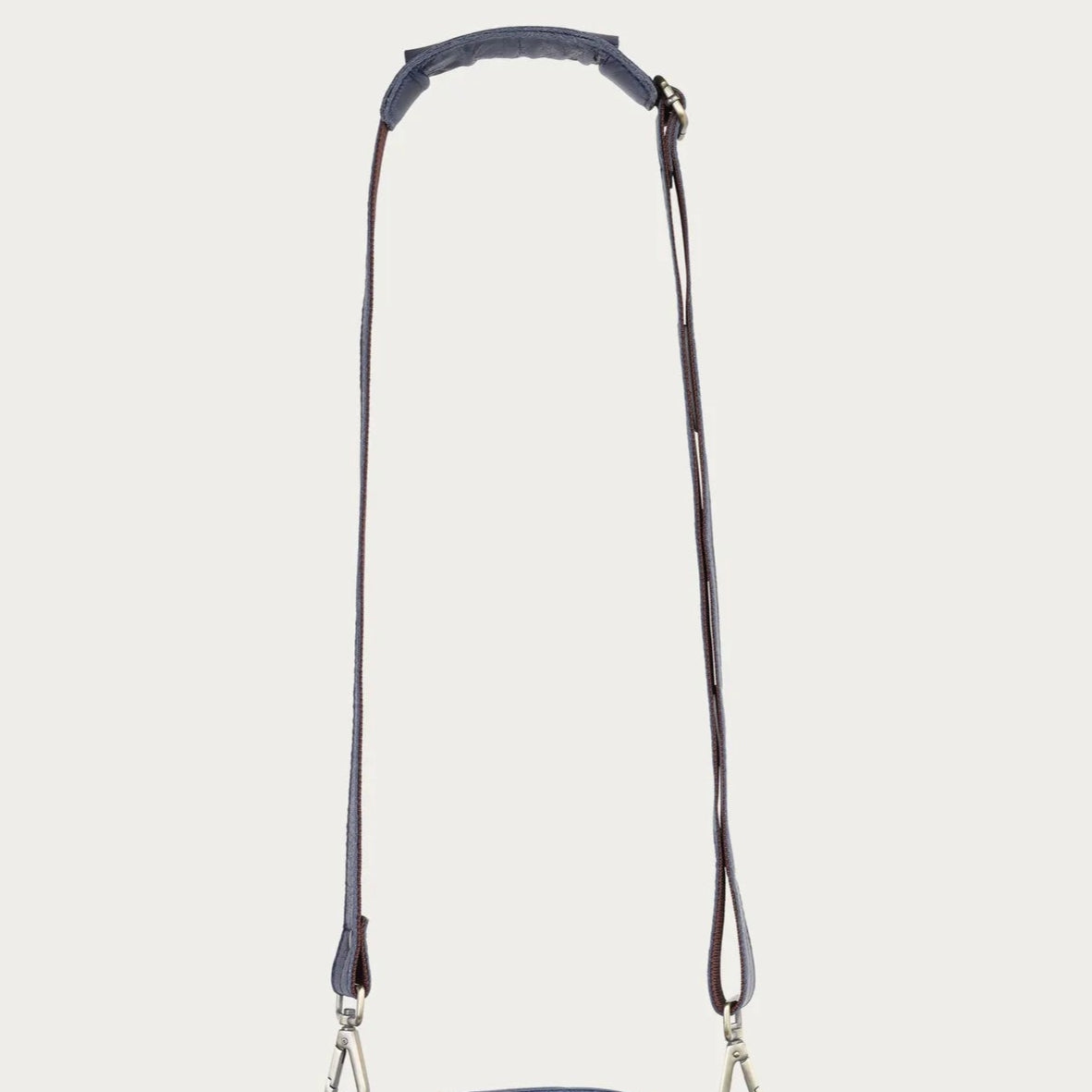 Blue leather satchel bag with a strap on a light gray background
