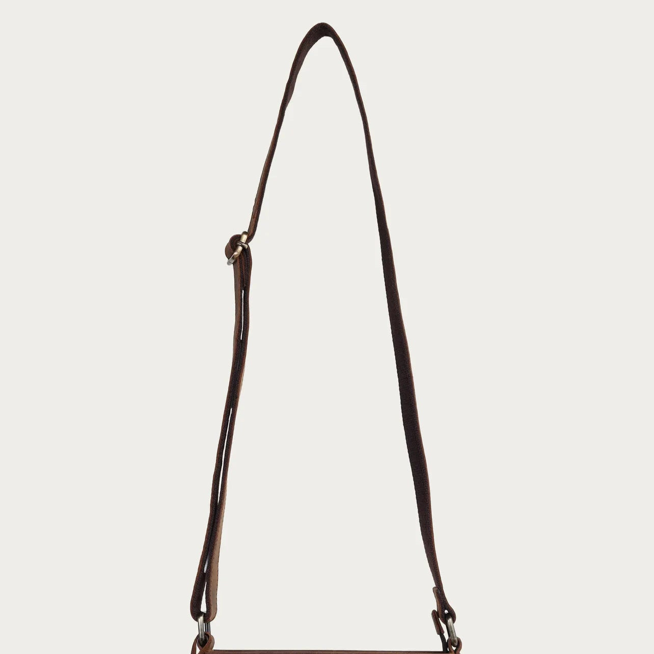 Brown leather crossbody bag on a light gray background
