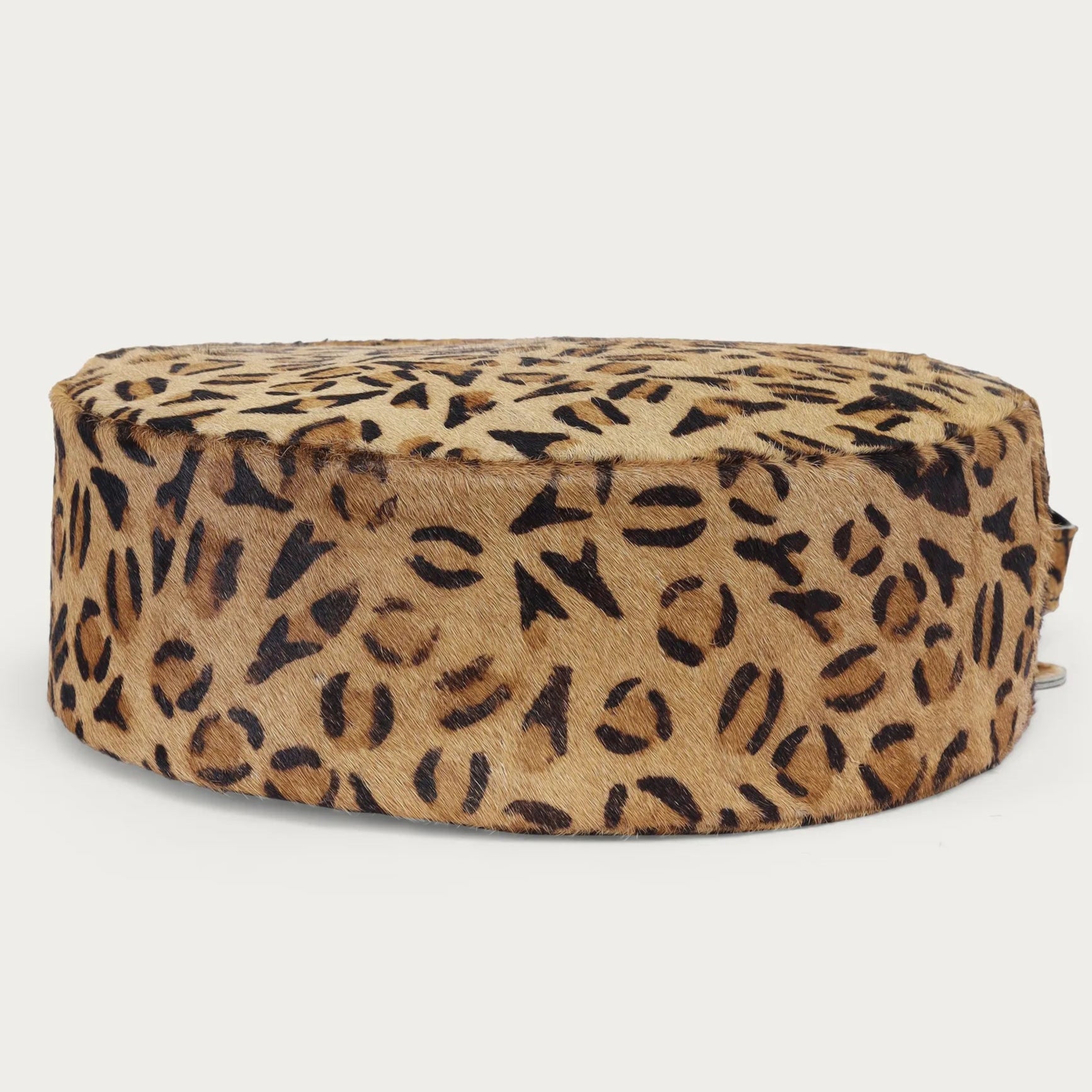 Round ottoman with leopard print pattern on a white background