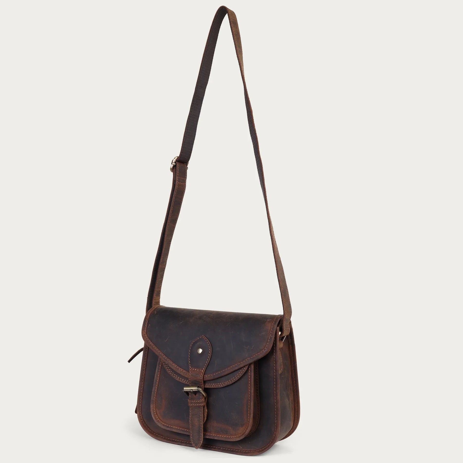 Brown leather satchel bag on a light gray background
