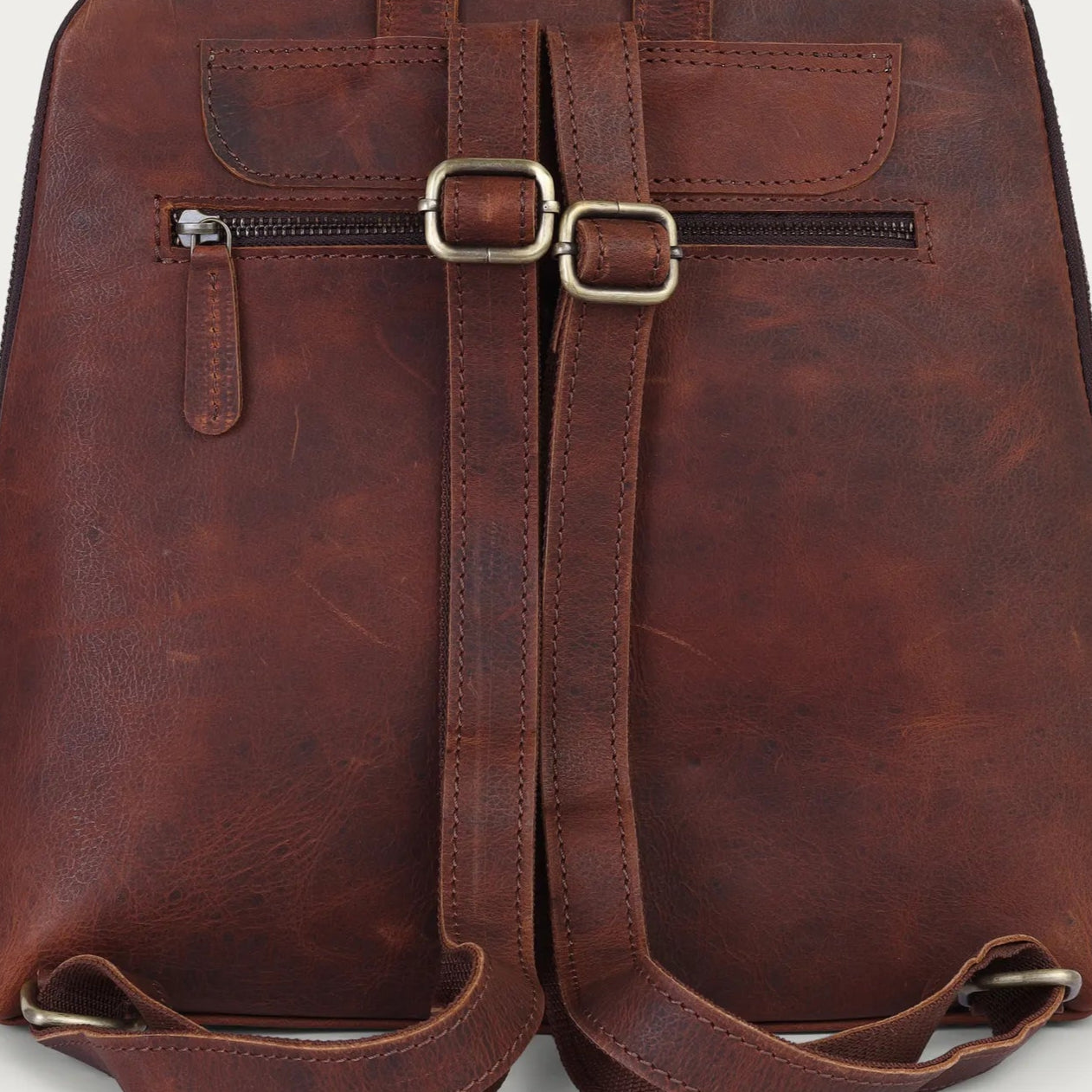 Brown leather backpack on a light gray background