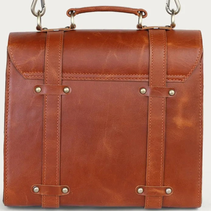 tan leather briefcase with a strap on a light gray background