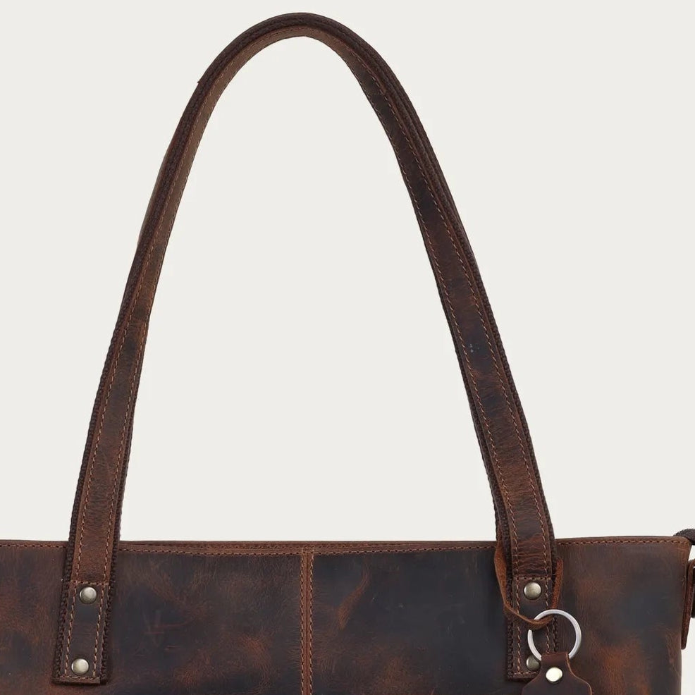 Brown leather tote bag on a light gray background